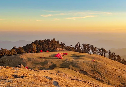 Group of trekkers sitting around a camping table inside a white tent